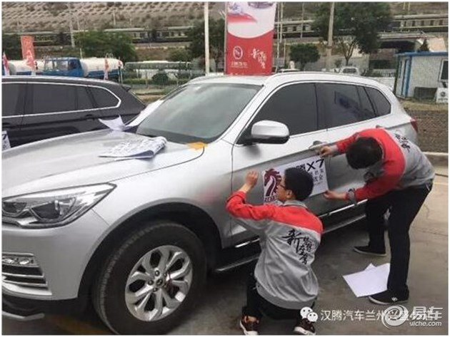 兰州兴盛汉腾4s店售后维修人员正在贴心的为各位车主爱车张贴红马会车