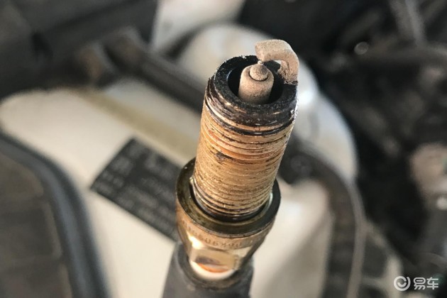 先拆火花塞,来看看,火花塞头部的积碳确实是不少,可以很明显的看到